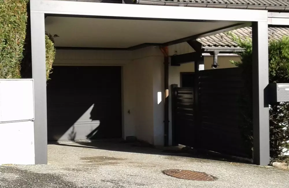 abri de voiture devant la porte de garage